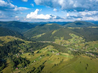 Yazın Ukrayna Karpatları 'nın yeşil dağları. Güneşli bir gün, nadir bulutlar. Hava aracı görünümü.