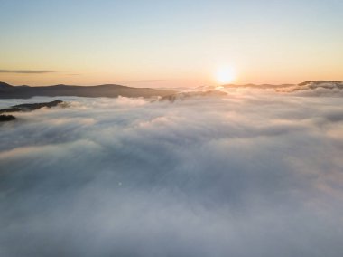 Ukrayna Karpatları 'nda sisin üstünde gün doğumu. Hava aracı görünümü.