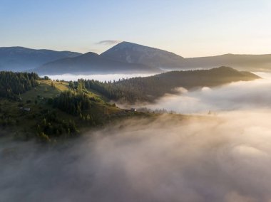 Ukrayna Karpatları 'nda sisin üstünde gün doğumu. Hava aracı görünümü.