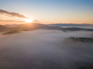 Ukrayna Karpatları 'nda sisin üstünde gün doğumu. Hava aracı görünümü.