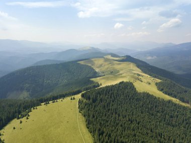 Yazın Ukrayna Karpatları 'nın yeşil dağları. Güneşli bir gün, nadir bulutlar. Hava aracı görünümü.