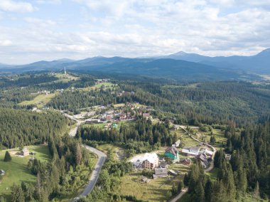 Yazın Ukrayna Karpatları 'nın yeşil dağları. Yamaçlarda kozalaklı ağaçlar. Hava aracı görünümü.