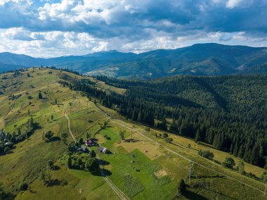 Yazın Ukrayna Karpatları 'nın yeşil dağları. Güneşli bir gün, nadir bulutlar. Hava aracı görünümü.