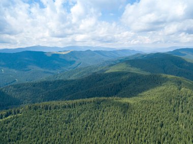 Yazın Ukrayna Karpatları 'nın yeşil dağları. Güneşli bir gün, nadir bulutlar. Hava aracı görünümü.