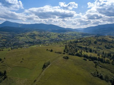 Yazın Ukrayna Karpatları 'nın yeşil dağları. Yamaçlarda kozalaklı ağaçlar. Hava aracı görünümü.