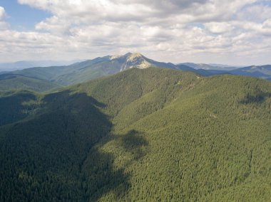 Yazın Ukrayna Karpatları 'nın yeşil dağları. Güneşli bir gün, nadir bulutlar. Hava aracı görünümü.