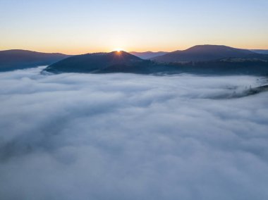 Ukrayna Karpatları 'nda sisin üstünde gün doğumu. Hava aracı görünümü.