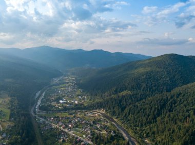 Yazın Ukrayna Karpatları 'nın yeşil dağları. Yamaçlarda kozalaklı ağaçlar. Hava aracı görünümü.