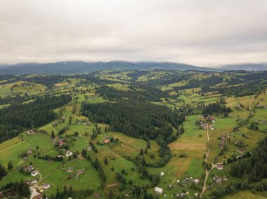 Yazın Ukrayna Karpat Dağları 'nın yeşil yamaçlarında. Bulutlu bir sabah, alçak bulutlar. Hava aracı görünümü.