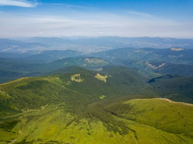 Bulutlu havada Ukrayna Karpatlarının yüksek dağları. Hava aracı görünümü.
