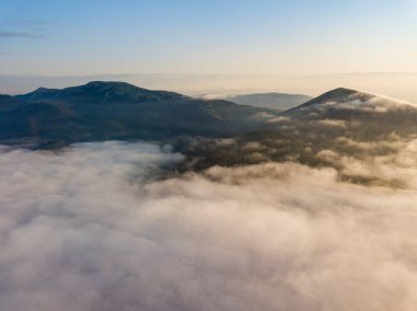 Ukrayna Karpatları 'nda yaz aylarında sislerin üzerinden uçarlar. Ufuktaki dağlar. Hava aracı görünümü.