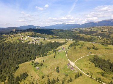 Yazın Ukrayna Karpatları 'nın yeşil dağları. Güneşli bir gün, nadir bulutlar. Hava aracı görünümü.
