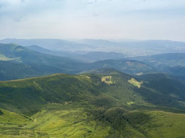 Bulutlu havada Ukrayna Karpatlarının yüksek dağları. Hava aracı görünümü.