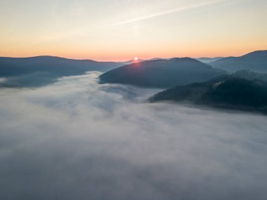Ukrayna Karpatları 'nda sisin üstünde gün doğumu. Hava aracı görünümü.