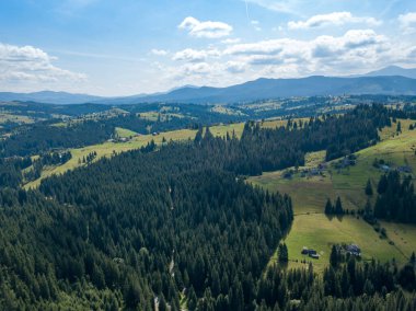 Yazın Ukrayna Karpatları 'nın yeşil dağları. Güneşli bir gün, nadir bulutlar. Hava aracı görünümü.