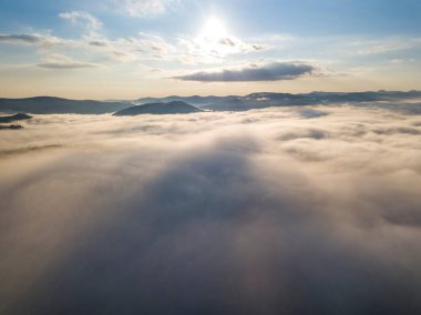 Ukrayna Karpatları 'nda yaz aylarında sislerin üzerinden uçarlar. Ufuktaki dağlar. Yoğun bir sis tabakası daimi bir halıyla dağları kaplar. Hava aracı görünümü.