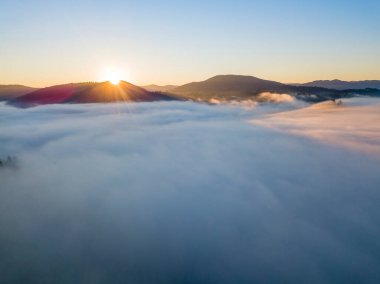 Ukrayna Karpatları 'nda sisin üstünde gün doğumu. Hava aracı görünümü.