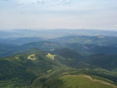 Bulutlu havada Ukrayna Karpatlarının yüksek dağları. Hava aracı görünümü.