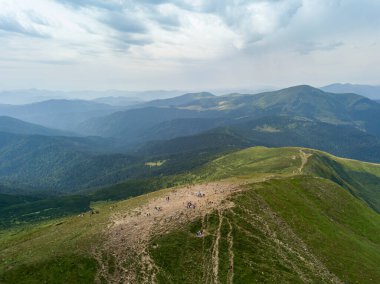 Bulutlu havada Ukrayna Karpatlarının yüksek dağları. Hava aracı görünümü.