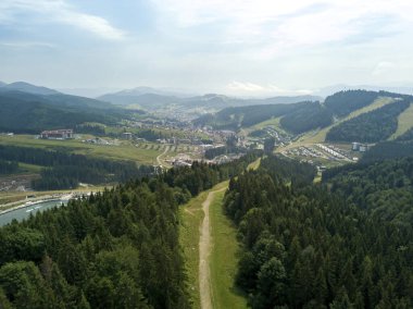 Yazın Ukrayna Karpatları 'nın yeşil dağları. Güneşli bir gün, nadir bulutlar. Hava aracı görünümü.