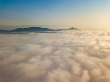 Ukrayna Karpatları 'nda yaz aylarında sislerin üzerinden uçarlar. Ufuktaki dağlar. Hava aracı görünümü.