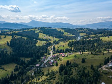 Yazın Ukrayna Karpatları 'nın yeşil dağları. Güneşli bir gün, nadir bulutlar. Hava aracı görünümü.