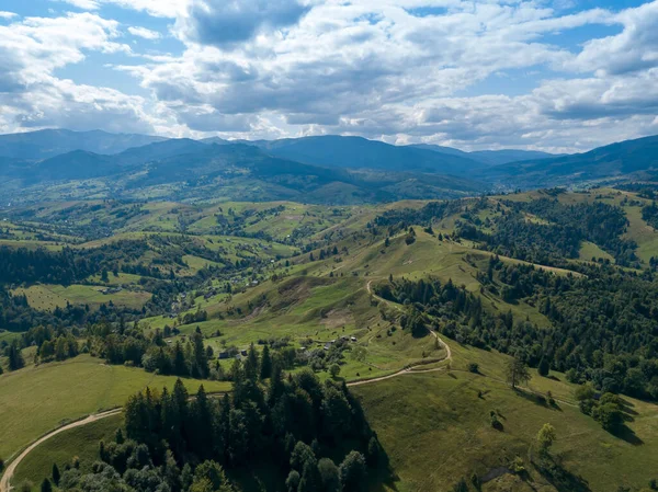 Yazın Ukrayna Karpatları 'nın yeşil dağları. Yamaçlarda kozalaklı ağaçlar. Hava aracı görünümü.