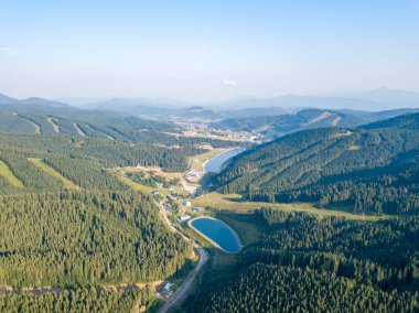 Yazın Ukrayna Karpatları 'nın yeşil dağları. Güneşli bir gün, nadir bulutlar. Hava aracı görünümü.