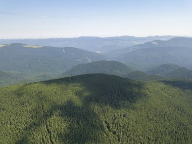 Bulutlu havada Ukrayna Karpatlarının yüksek dağları. Hava aracı görünümü.