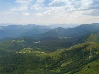 Bulutlu havada Ukrayna Karpatlarının yüksek dağları. Hava aracı görünümü.