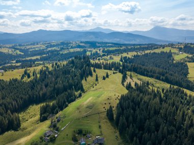 Yazın Ukrayna Karpatları 'nın yeşil dağları. Güneşli bir gün, nadir bulutlar. Hava aracı görünümü.