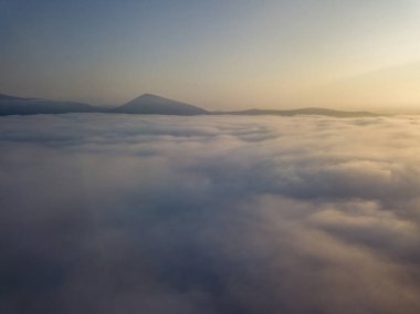Ukrayna Karpatları 'nda sisin üstünde gün doğumu. Hava aracı görünümü.