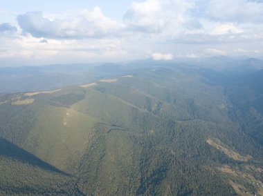 Yazın Ukrayna Karpat Dağları 'nın yeşil yamaçlarında. Bulutlu bir gün, alçak bulutlar. Hava aracı görünümü.