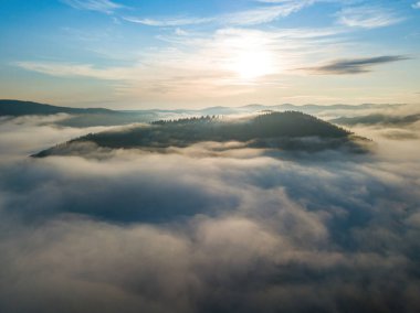 Sisli Karpatlar 'da güneşli bir sabah. Dağları ince bir sis tabakası kaplıyor. Hava aracı görünümü.