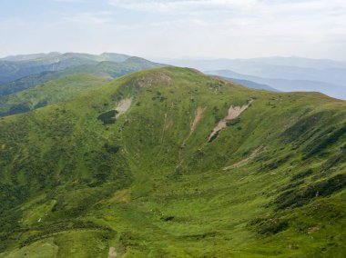 Bulutlu havada Ukrayna Karpatlarının yüksek dağları. Hava aracı görünümü.