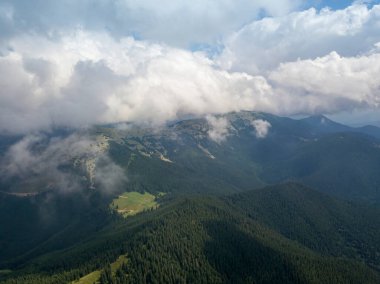 Yazın Ukrayna Karpatları 'nın yeşil dağları. Güneşli bir gün, nadir bulutlar. Hava aracı görünümü.