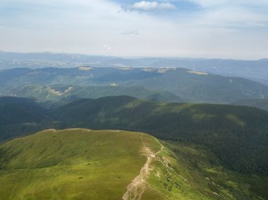 Bulutlu havada Ukrayna Karpatlarının yüksek dağları. Hava aracı görünümü.