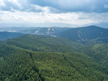Yazın Ukrayna Karpatları 'nın yeşil dağları. Güneşli bir gün, nadir bulutlar. Hava aracı görünümü.