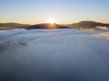 Ukrayna Karpatları 'nda sisin üstünde gün doğumu. Hava aracı görünümü.