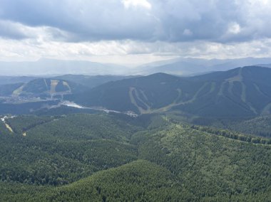 Yazın Ukrayna Karpatları 'nın yeşil dağları. Güneşli bir gün, nadir bulutlar. Hava aracı görünümü.