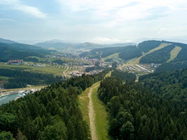 Yazın Ukrayna Karpatları 'nın yeşil dağları. Güneşli bir gün, nadir bulutlar. Hava aracı görünümü.