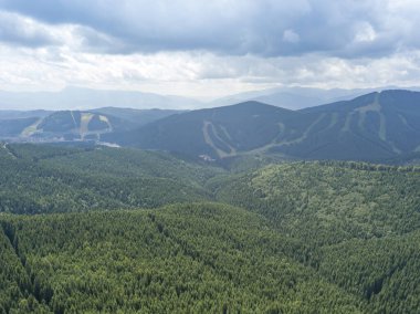 Yazın Ukrayna Karpatları 'nın yeşil dağları. Güneşli bir gün, nadir bulutlar. Hava aracı görünümü.