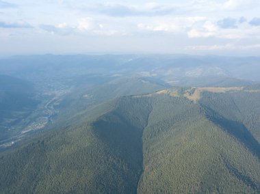 Yazın Ukrayna Karpat Dağları 'nın yeşil yamaçlarında. Bulutlu bir gün, alçak bulutlar. Hava aracı görünümü.