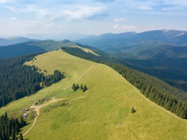 Yazın Ukrayna Karpatları 'nın yeşil dağları. Güneşli bir gün, nadir bulutlar. Hava aracı görünümü.