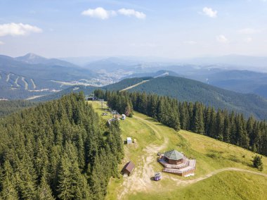 Yazın Ukrayna Karpatları 'nın yeşil dağları. Güneşli bir gün, nadir bulutlar. Hava aracı görünümü.