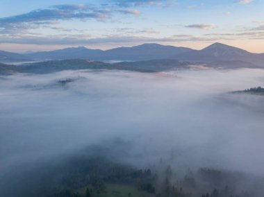 Ukrayna Karpatları 'nda sisin üstünde gün doğumu. Hava aracı görünümü.