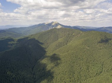 Yazın Ukrayna Karpatları 'nın yeşil dağları. Güneşli bir gün, nadir bulutlar. Hava aracı görünümü.