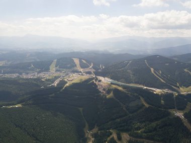 Yazın Ukrayna Karpatları 'nın yeşil dağları. Güneşli bir gün, nadir bulutlar. Hava aracı görünümü.