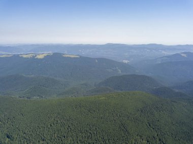 Bulutlu havada Ukrayna Karpatlarının yüksek dağları. Hava aracı görünümü.
