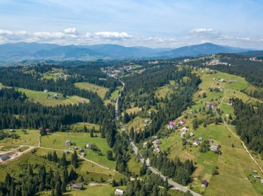 Yazın Ukrayna Karpatları 'nın yeşil dağları. Güneşli bir gün, nadir bulutlar. Hava aracı görünümü.